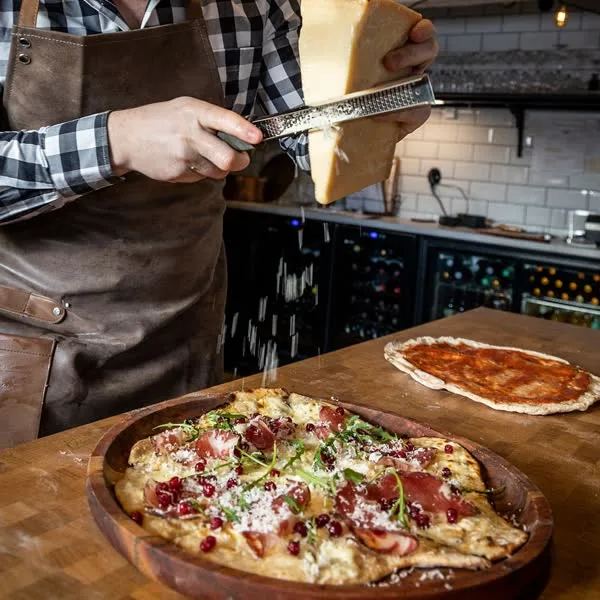 Pizzabak i vedugnen i Bistro Lilla Stallet